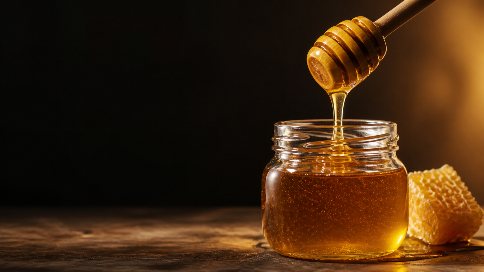 Honey pouring into a clear jar
